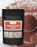 Stone-ground ragi flour in black resealable pouch with bowl of finger millet grains