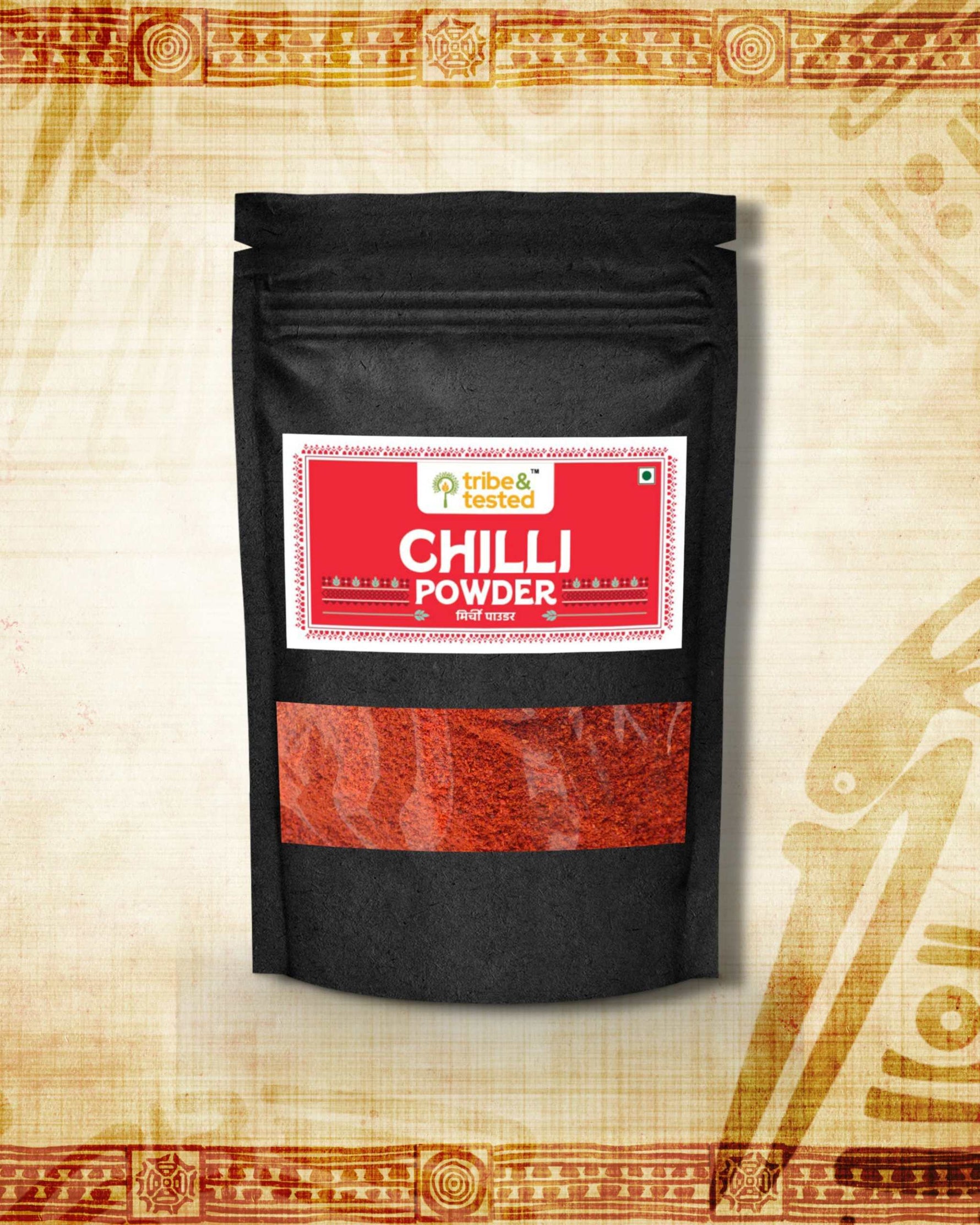 Stone-ground red chilli powder in black resealable pouch with traditional Indian design background